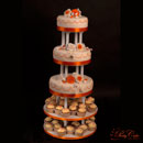 bruidstaart met oranje en witte rozen en cupcakes